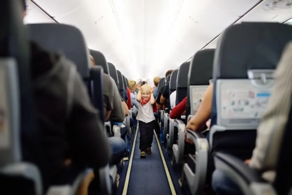 Image of Happy little boy during traveling by an airplane. Traveling with kids. Family enjoying trip in aircraft. Transportation safety