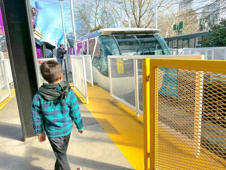 Check out these tips for riding the Seattle Monorail by top Seattle travel blog Marcie in Mommyland. Image of a boy waiting for the Seattle Center Monorail.