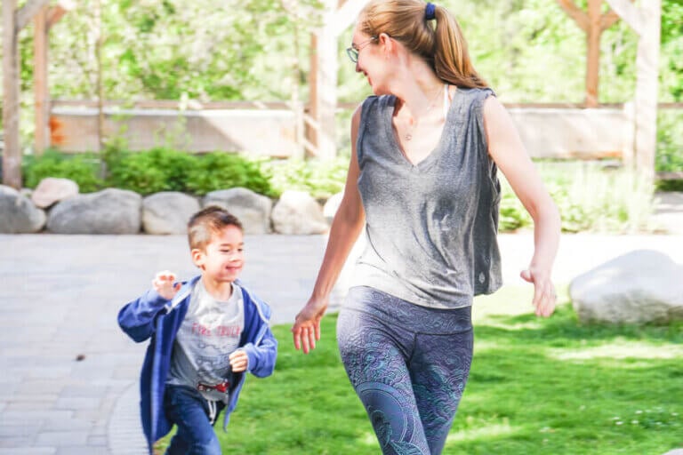 Photo of a mom and boy playing tag in a park in Withrop, Washington as a way to stay healthy during family travel #yogaclub #playing #kids #parenting #familytravel