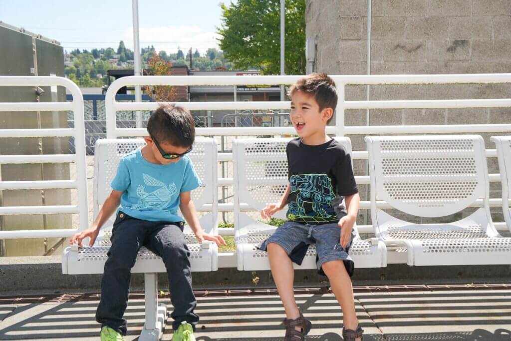 Photo of boys waiting for the Sounder train in Kent, Washington, a fun thing to do in Seattle with kids #kentwashington #visitkent #kentstation #seattlwa #seattlewithkids #seattletrain