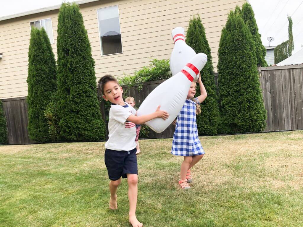 Photo of kids playing with inflatable bowling pins from Zulily #zulily #bowling #bbq #lawngames
