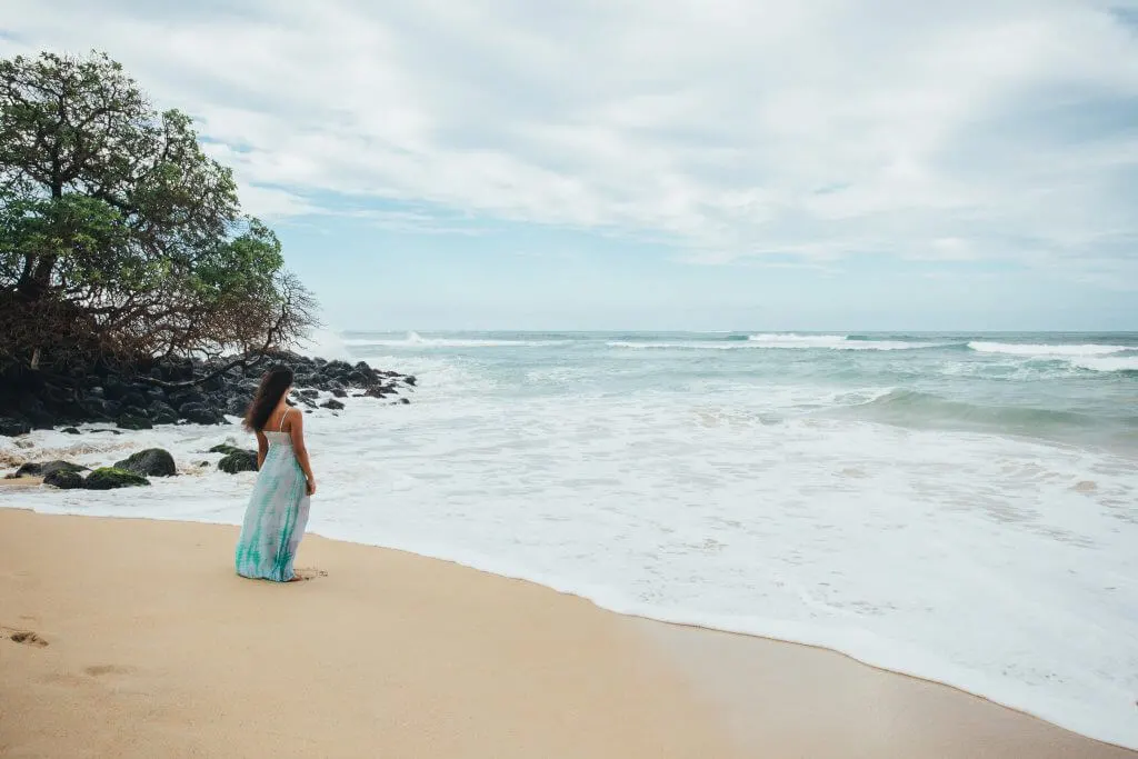 Photo of a woman watching the surf in Maui, a popular babymoon destination in Hawaii #maui #hawaii #babymoon #tropicalbabymoon #zikafreebabymoon
