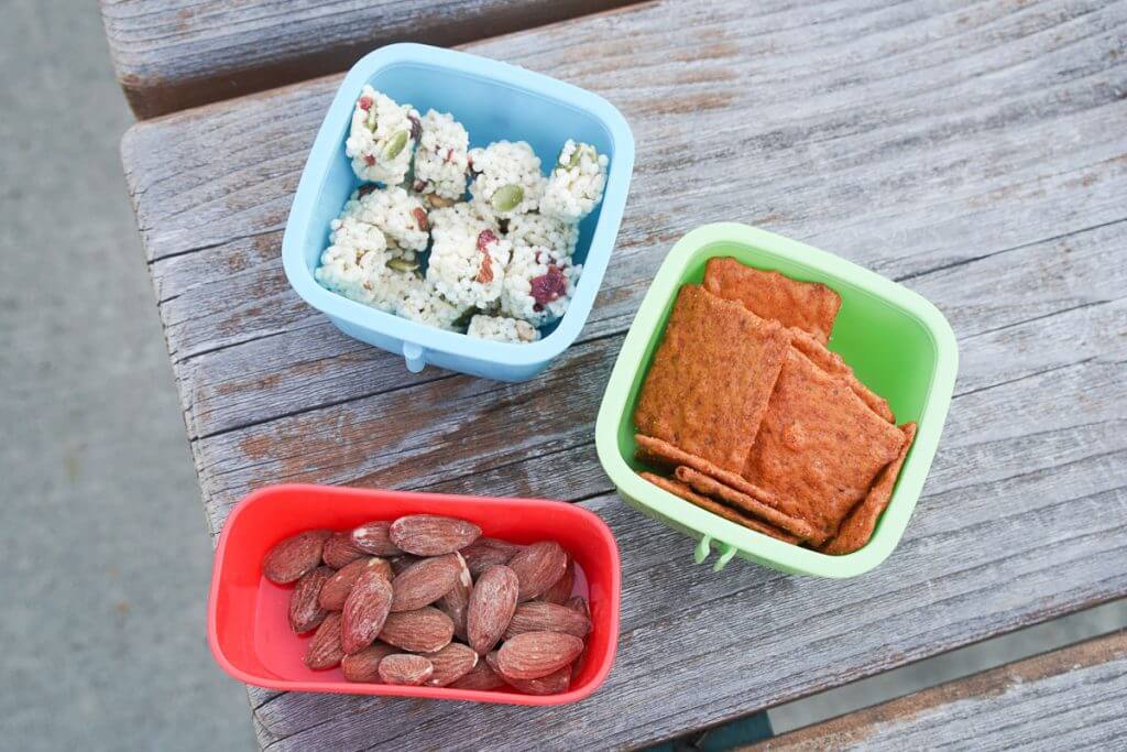 Photo of almonds, crackers, and other snacks perfect for a summer play date in the park or a toddler lunch or mom lunch idea #lunch #almonds #toddlerlunch #momlunch #momonthego