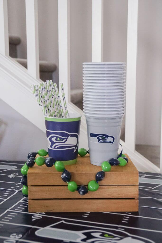 Photo of officially licensed NFL cups and kukui nut necklace for the Seattle Seahawks #seahawks #nfl #seattleseahawks #kukuinut #paperstraws #seahawksparty