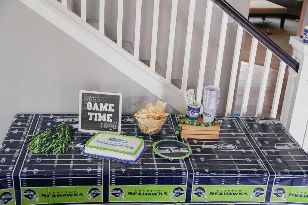 Photo of a Seattle Seahawks snack table featuring an officially licensed NFL cake from DecoPac #decopac #nfl #nflcake #footballcake #footballparty #footballtheme