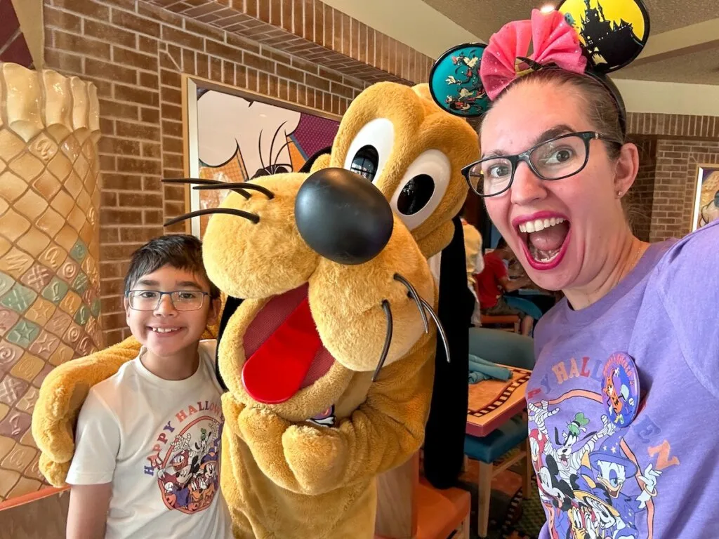 Image of Marcie Cheung of Marcie in Mommyland and her son with Pluto at a Disneyland character breakfast