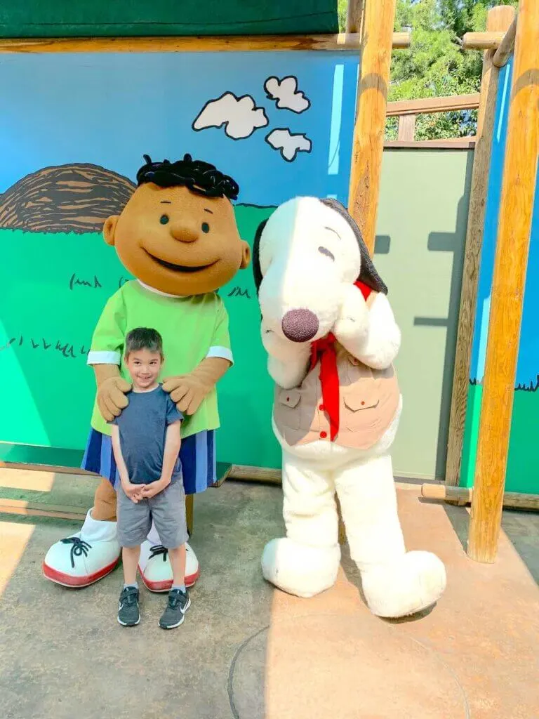 Image of a boy posing with Franklin and Snoopy at Knott's Berry Farm