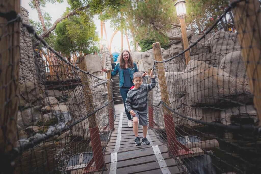 Image of a mom and son walking across a wooden bridge at Knott's Berry Farm.