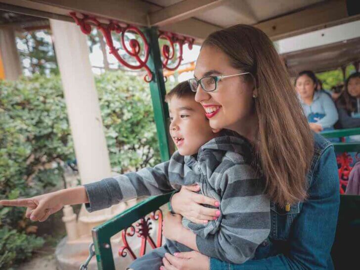 Check out the top Knott's Berry Farm kids activities recommended by top family travel blog Marcie in Mommyland. Image of a mom and boy riding a train at Knott's Berry Farm in Buena Park, CA