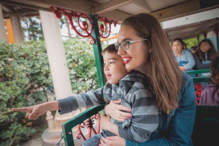 Check out the top Knott's Berry Farm kids activities recommended by top family travel blog Marcie in Mommyland. Image of a mom and boy riding a train at Knott's Berry Farm in Buena Park, CA