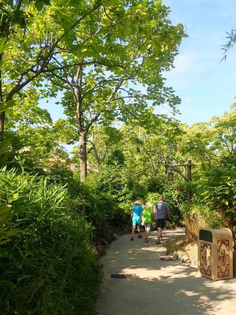 Image of a family walking through a greenery-filled path at Disneyland Paris