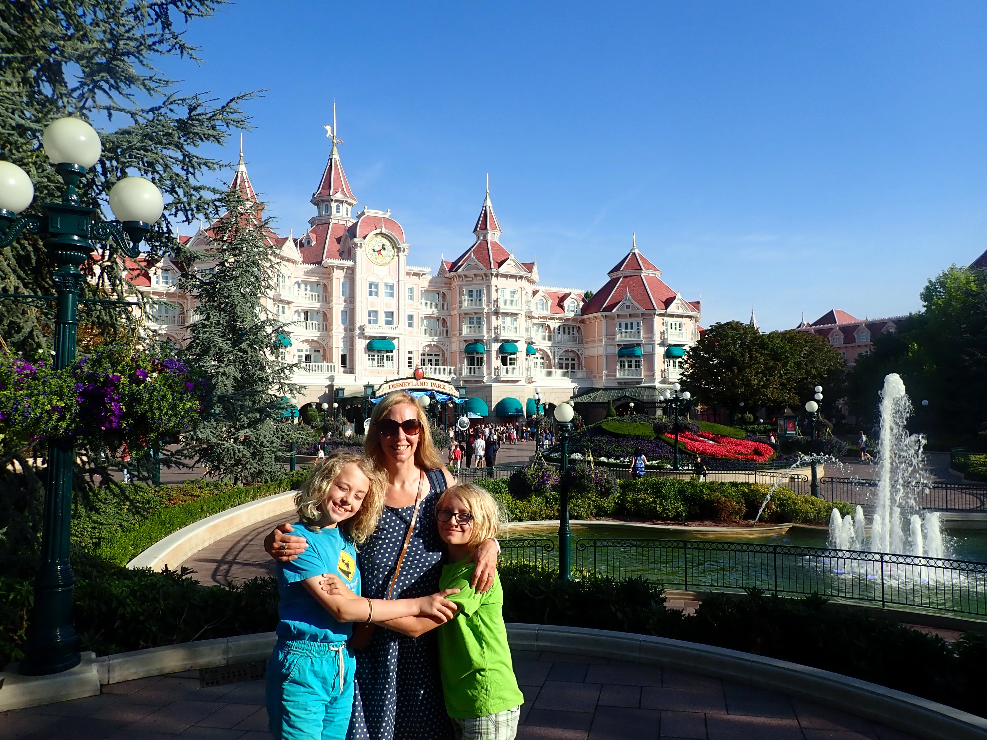 Disneyland Paris One Day Itinerary featured by top US Disney blogger, Marcie and the Mouse: Mom and two kids standing in front of the Disneyland Paris entrance