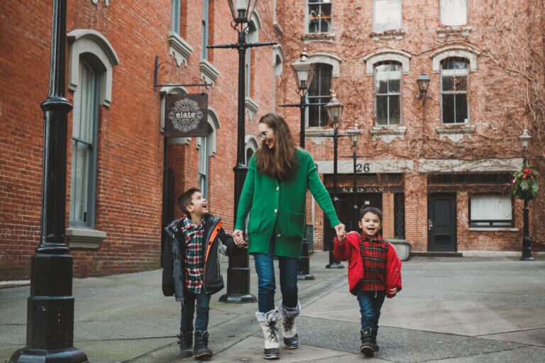Christmas in Victoria BC: the Best Kid Friendly Festivities featured by top US family travel blogger, Marcie in Mommyland: A mom and two boys walking around Victoria, BC in December