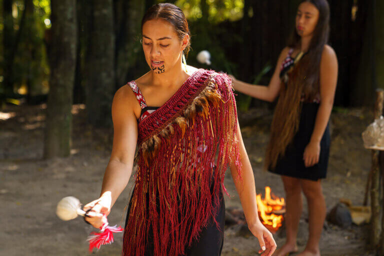 Tamaki Maori Village in Rotorua in New Zealand, a review featured by top US travel blogger, Marcie in Mommyland: Maori women dressed in traditional Maori attire using a poi ball