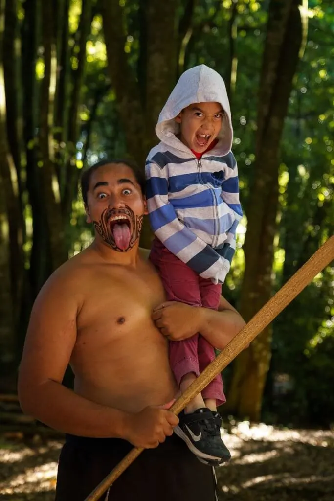 Tamaki Maori Village in Rotorua in New Zealand, a review featured by top US travel blogger, Marcie in Mommyland: Boy poses with a Maori Warrior at the Tamaki Maori Village in Rotorua, New Zealand