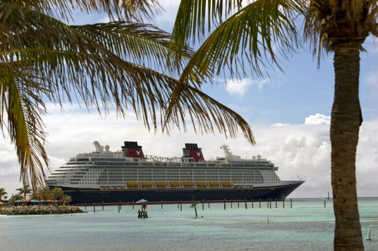 How to Save Money on Disney Cruise Line: Top 10 Money Saving Tips featured by top US Disney blogger, Marcie and the Mouse: c The Disney Fantasy docks at Castaway Cay, Disney's private island in the tropical waters of the Bahamas, reserved exclusively for Disney Cruise Line guests. In a setting of crystal-clear turquoise waters, powdery white-sand beaches and lush landscapes, the 1,000-acre island offers one-of-a-kind areas and activities for every member of the family. Photo Credit: Kent Phillips