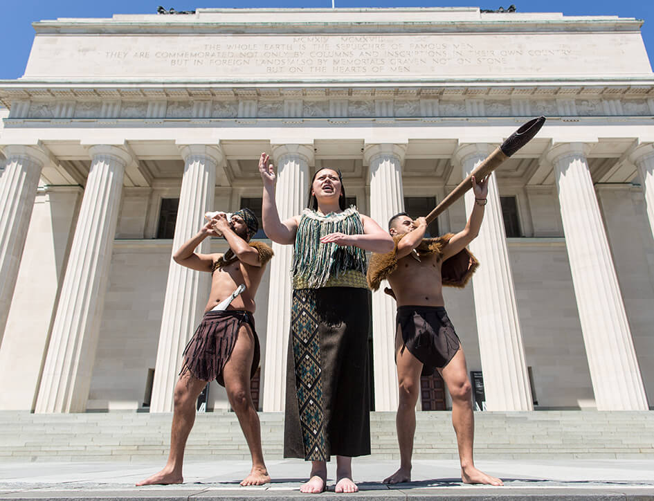 Top 13 Free Things to do in Auckland New Zealand featured by top international family travel blogger, Marcie in Mommyland: Maori performers outside of the Auckland War Museum in Auckland New Zealand