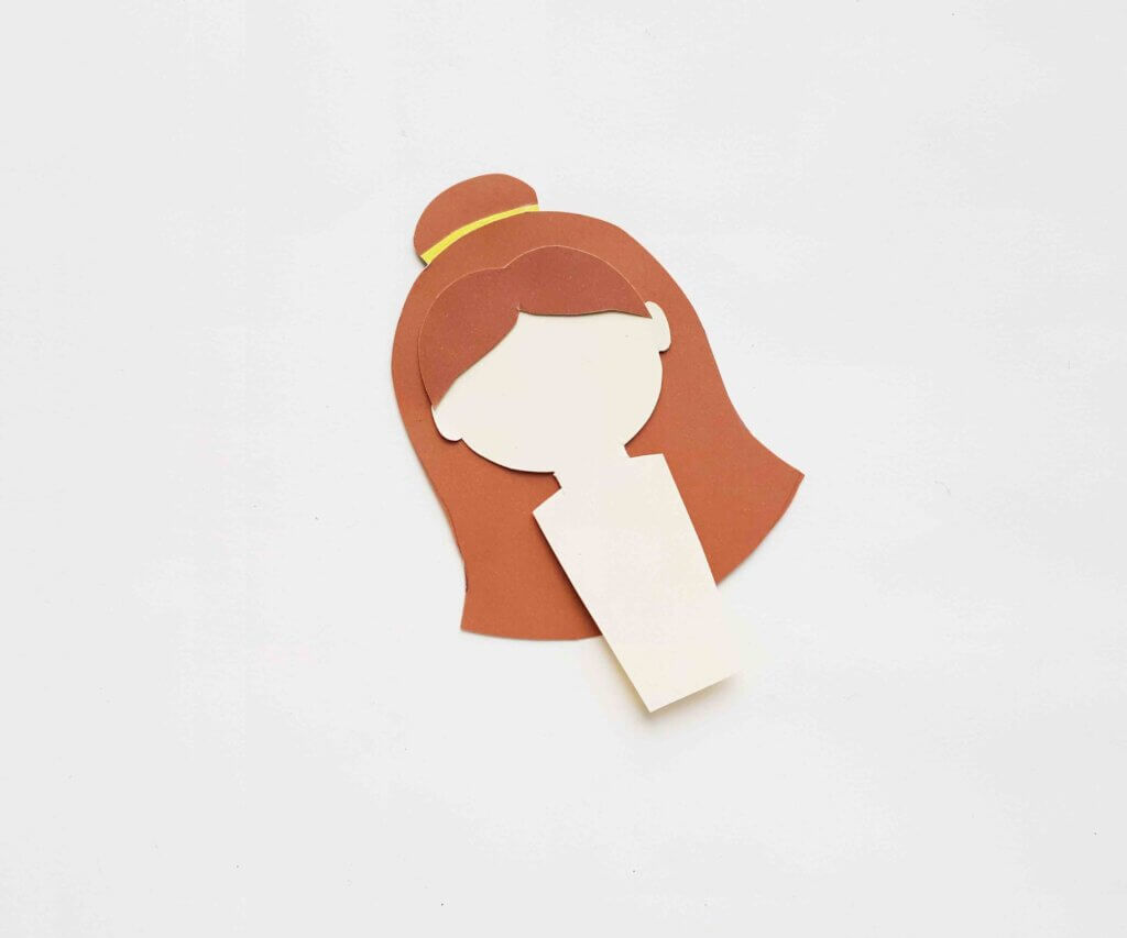 Image of a cream paper doll body with brown hair and a yellow crown