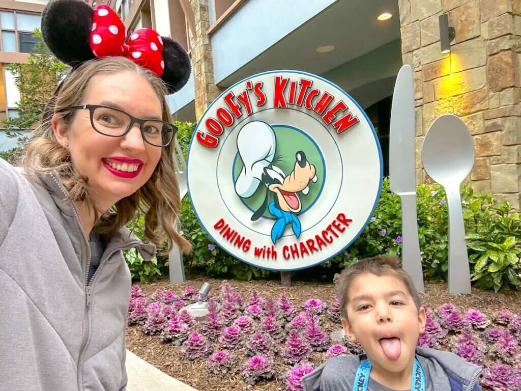 Image of a mom and boy taking a selfie in front of the Goofy's Kitchen sign at the Disneyland Hotel