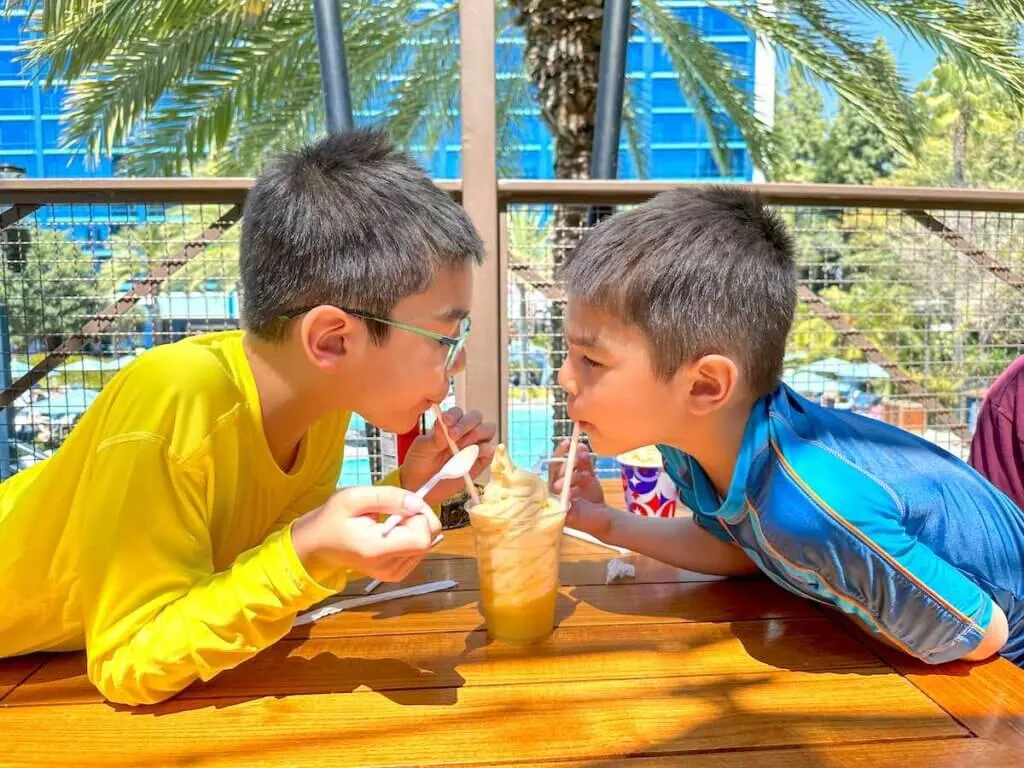 Image of two boys sipping a Dole Whip float at the Disneyland Hotel