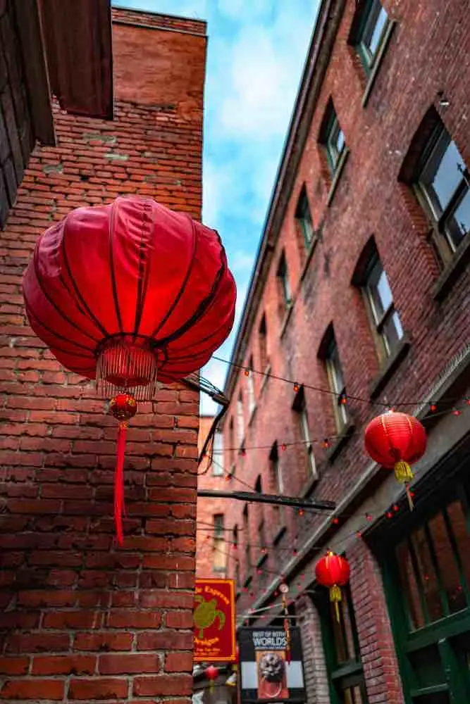 Victoria with Kids: 13 Kids Activities to Do when Visiting Victoria Canada featured by top family travel blogger, Marcie in Mommyland: A vertical low angle shot of Chinese lanterns in Fan Tan Alley, Chinatown, Victoria, BC Canada