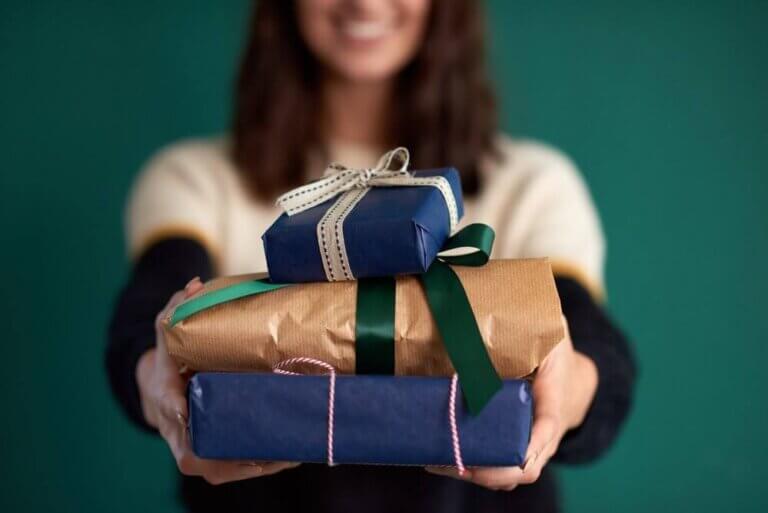 Top 12 Under $50 Christmas Gifts featured by top Seattle lifestyle blogger, Marcie in Mommyland: Image of anonymous woman holding homewrapped presents to the camera, creative DIY gift wrap birthday christmas celebration