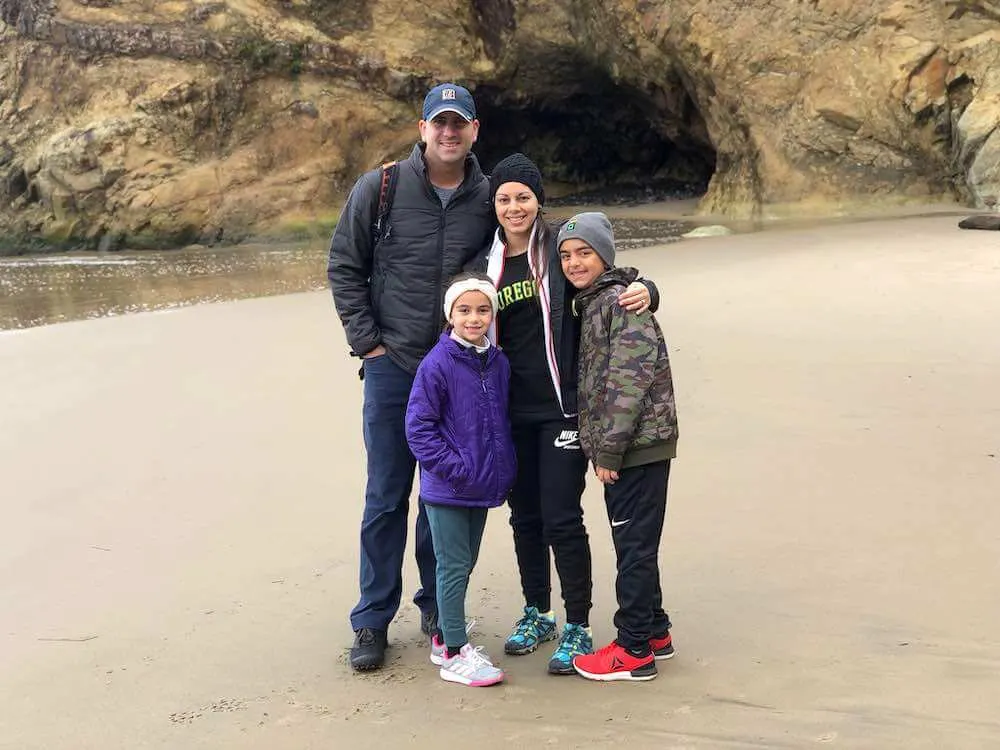 Best Winter Weekend Getaways from Seattle featured by top Seattle travel blogger, Marcie in Mommyland: Image of a family posing at Arch Cape Oregon in winter