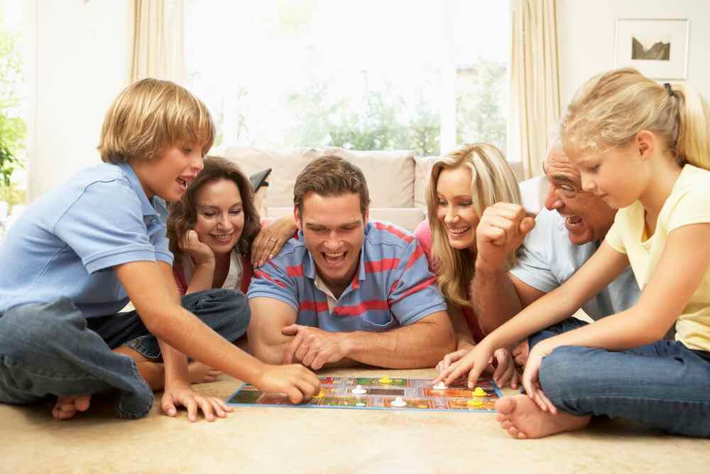 Playing board games is a fun Christmas activity for kids. Image of Family Playing Board Game At Home With Grandparents Watching
