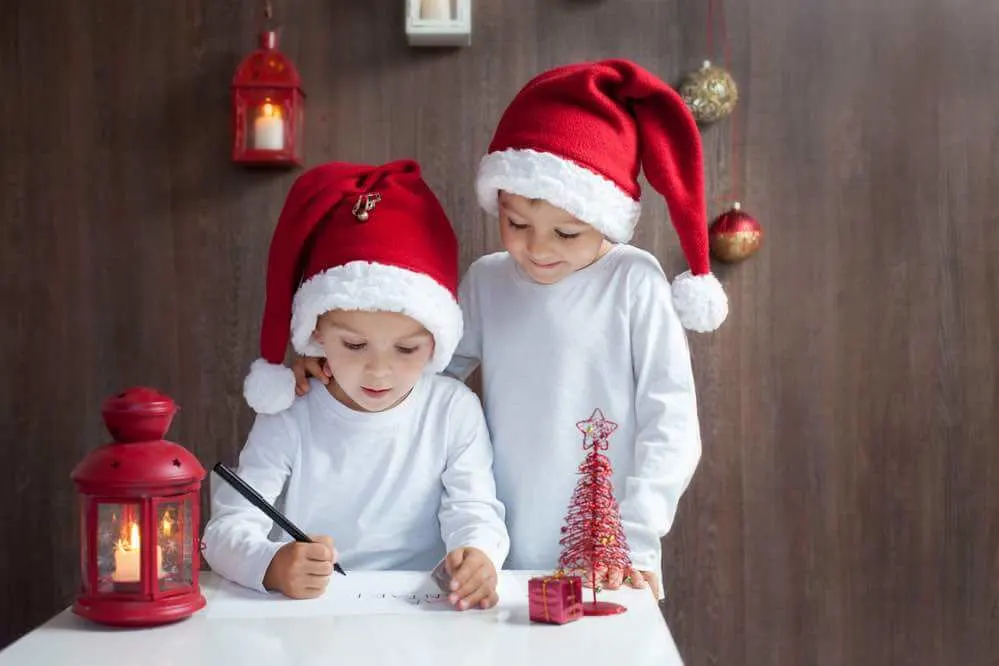 15 Free Festive Christmas Traditions That Don't Cost a Dime featured by top Seattle lifestyle blogger, Marcie in Mommyland: Writing a letter to Santa is an easy Christmas tradition for kids. Image of Two adorable boys, writing letter to Santa