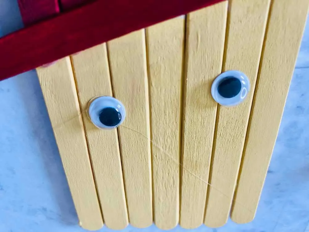 How to make a popsicle stick scarecrow craft step 5. Image of googly eyes on the scarecrow