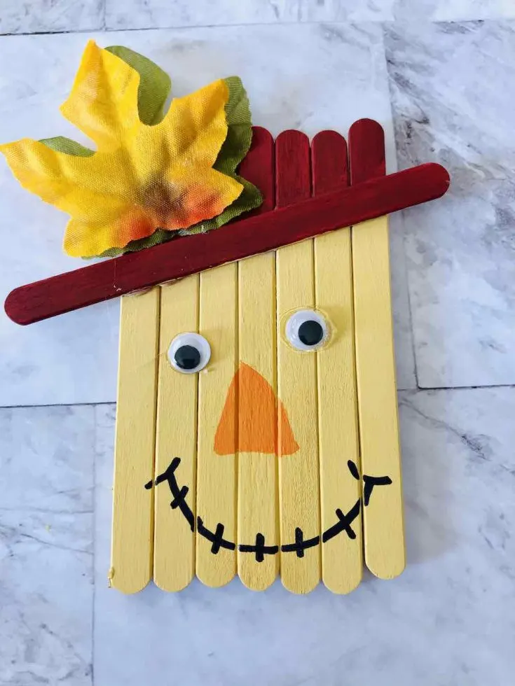 How to make a popsicle stick scarecrow craft. Image of the mouth drawn on