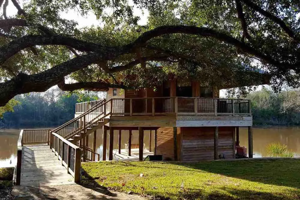 Top 7 Best Airbnbs for Christmas in the US featured by top US travel blogger, Marcie in Mommyland: Get this whole cozy cabin to yourself this Christmas. Image of a treehouse cabin by the lake.