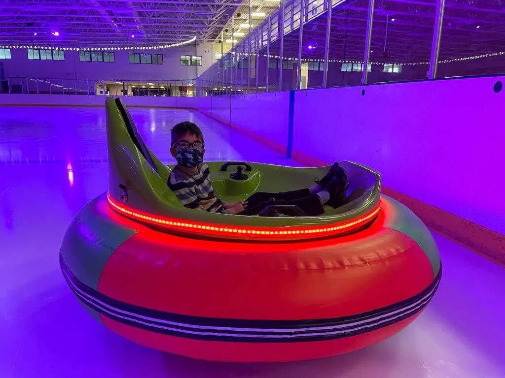 You can drive ice bumper cars in Spanaway, WA. Image of a boy sitting in an ice bumper car inside an ice skating rink.