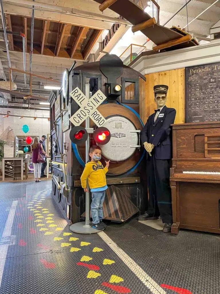 Definitely head to the Old Cannery Furniture Store in Sumner WA. Image of a boy posing in front of a giant train display.