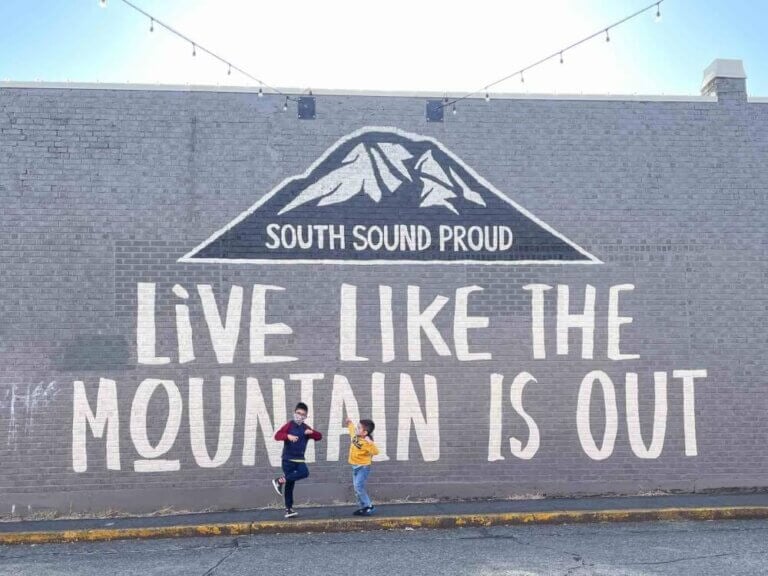 Find out the best South Sound Pacific Northwest vacations by top Seattle blog Marcie in Mommyland. Image of two boys in front of a mural that says "live like the mountain is out"