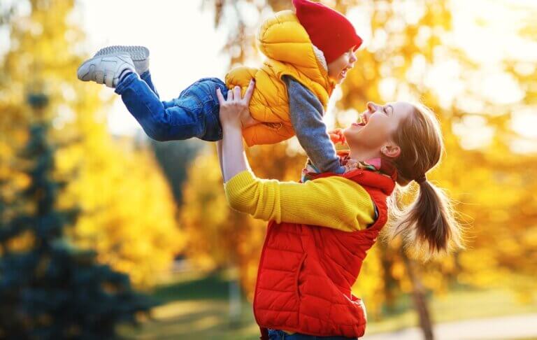 Get my free fall bucket list and free fall scavenger hunt printables by top Seattle blog Marcie in Mommyland. Image of happy family mother and baby son playing and laughing on autumn walk