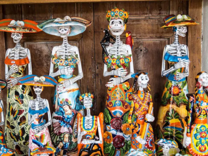 Find out the best small towns in Mexico for celebrating Day of the Dead. Image of brightly colored skeleton decorations in Mexico for Dia de los Muertos.