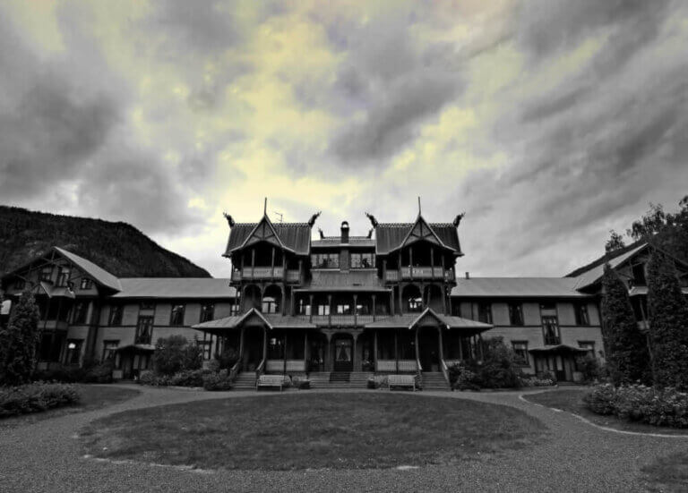 Find out the spookiest Halloween hotels in the United States by top Seattle blog Marcie in Mommyland. Image of a haunted mansion in black and white.