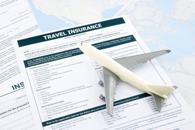 Find out whether or not you need Hawaii travel insurance by top Seattle blogger Marcie in Mommyland. Image of a toy airplane and travel insurance paperwork.