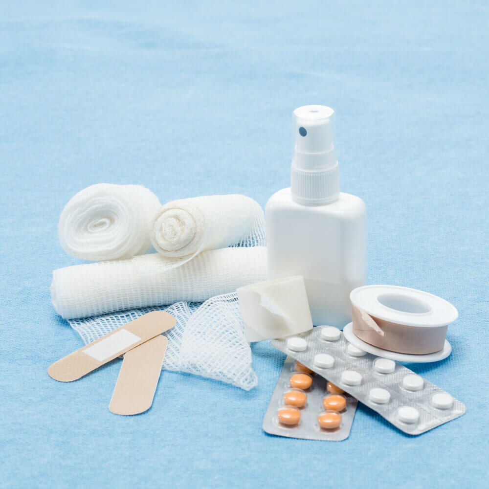Make sure to pack a variety of bandages in your family first aid kit for toddlers. Image of spray, bandages, and medicine.
