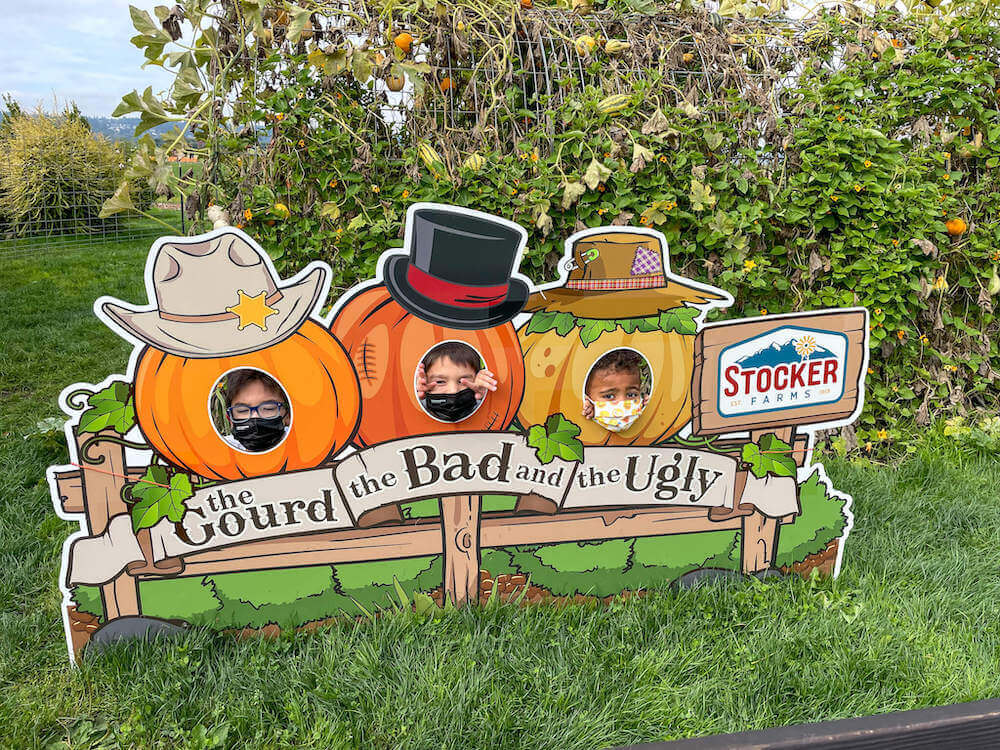 Image of three boys sticking their heads in a photo spot that says The Gourd, the Bad, and the Ugly