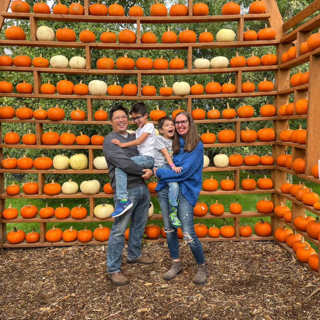 Image of a family smiling inside a pumpkin barn.