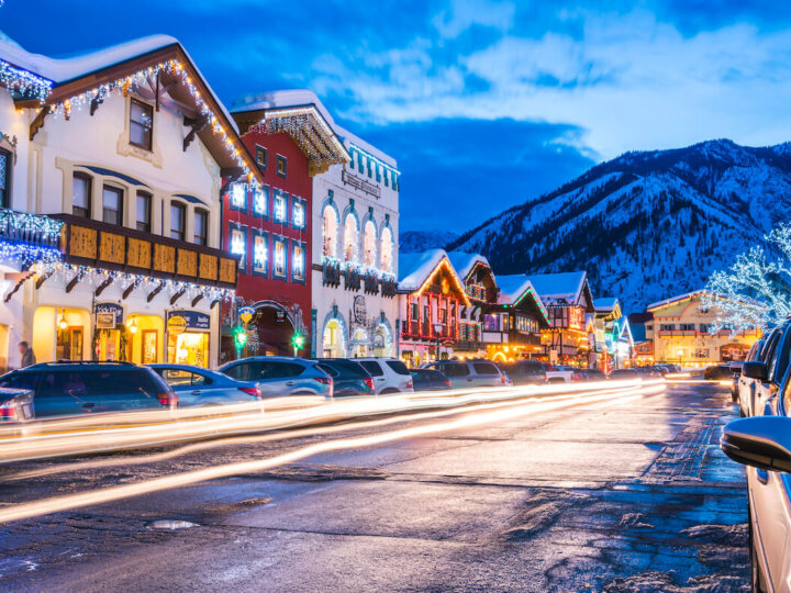 Find out the best Christmas getaways in the United States recommened by top Seattle blog Marcie in Mommyland. Image of a snowy mountain town with Christmas lights.