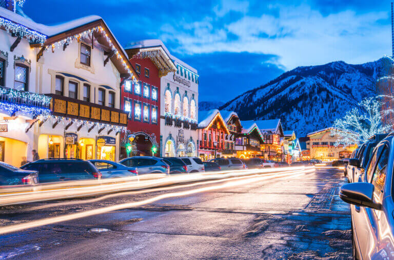 Find out the best Christmas getaways in the United States recommened by top Seattle blog Marcie in Mommyland. Image of a snowy mountain town with Christmas lights.