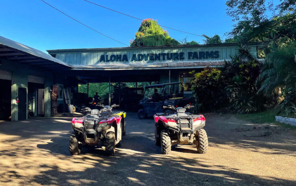 Image of ATVs parked in front of the Aloha Adventure Farms sign on the Big Island of Hawaii.
