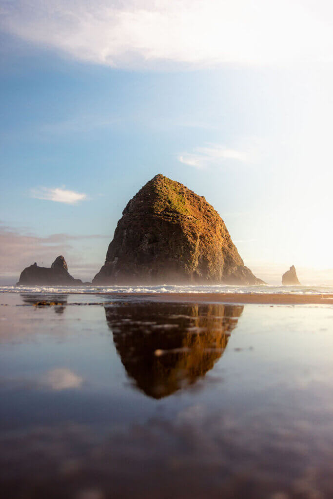 Image of Haystack Rock and it's reflection in the water in Cannon Beach Oregon.