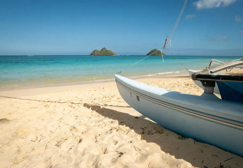 Image of an outrigger canoe at Kailua Beach Park with the Mokulua islands in the background.