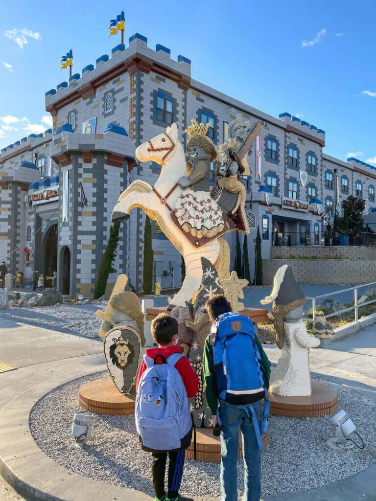 Image of two boys looking at a LEGO statue in front of the LEGOLAND Castle Hotel in California.