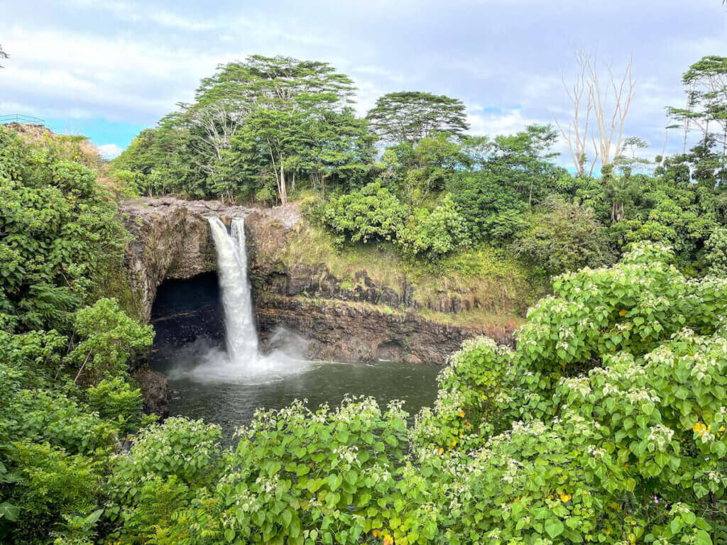 Image of a pretty Hawaiian waterfall surrounded by green trees and plants.