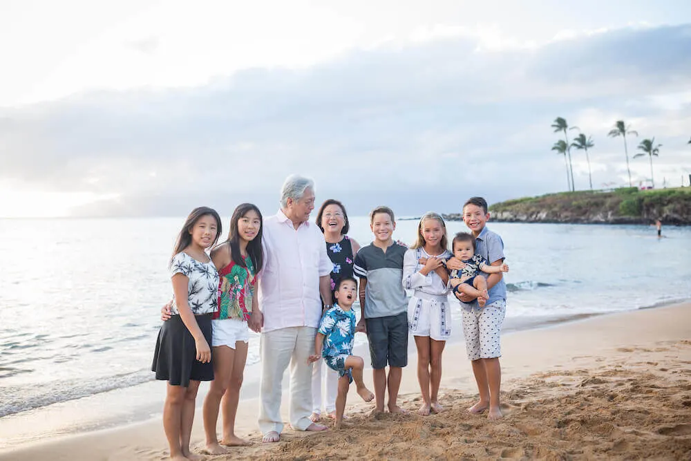 Image of grandparents with 7 grandkids at a Maui beach
